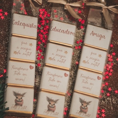 Três conjuntos de barras de chocolate com textos personalizados em português e desenhos de alce