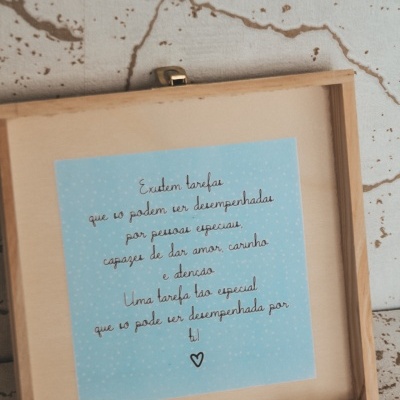 Caixa de madeira aberta com etiqueta azul contendo texto manuscrito em português no interior da tampa