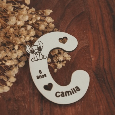 Letra branca em madeira com desenhos, texto e corações sobre madeira e flores secas