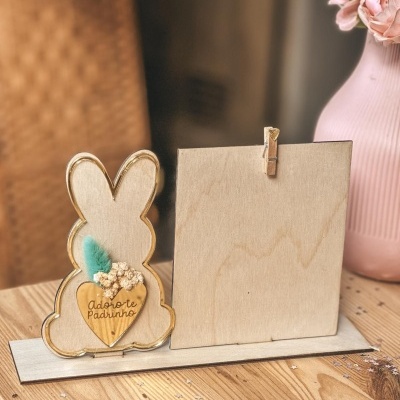 Suporte de madeira em forma de coelho com decoração e placas para fotografia sobre mesa de madeira