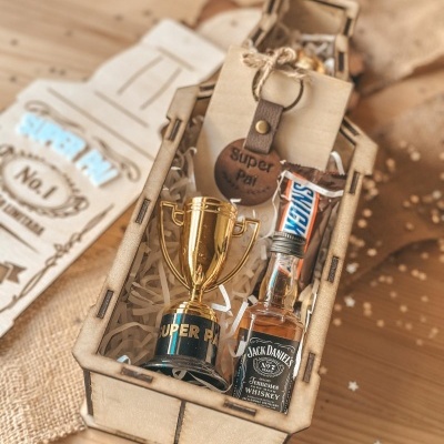 Conjunto presente numa caixa de madeira com troféu, mini whiskey Jack Daniels, chocolate Snickers e porta-chaves Super Pai