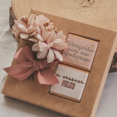 Caixa de presente com flores e chocolates com textos visíveis