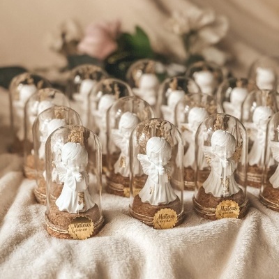 Figuras de anjos brancas sob cúpulas transparentes com base de cortiça e etiquetas douradas