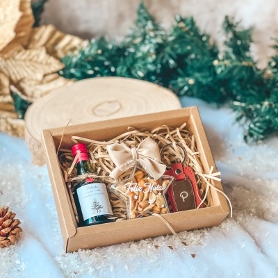 Conjunto de presente de Natal com mini garrafa, embalagem com amendoins e porta-chaves vermelho numa caixa de cartão