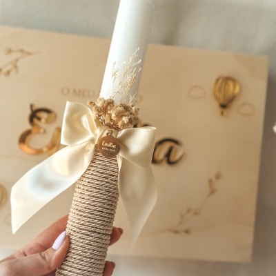 Vela decorada com laço, flores secas e pendente dourado