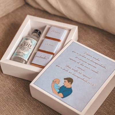 Caixa branca com mini garrafa de gin, chocolates e mensagem em azul