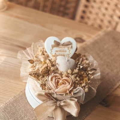 Arranjo decorativo com flores artificiais e corações em caixa redonda branca