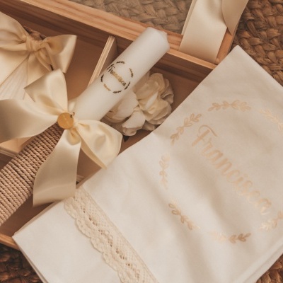 Conjunto decorativo de vela e saco em caixa de madeira sobre tapete de ráfia.