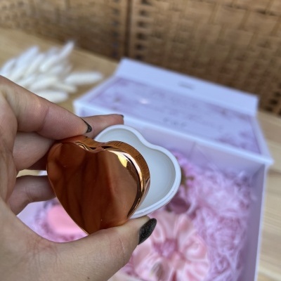 caixa de presente com itens em tons de rosa e caixa coração espelhada dourada