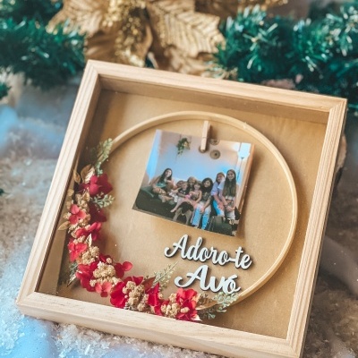 Moldura quadrada com flores secas vermelhas e douradas, foto e texto 'Adoro-te Avó'.