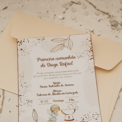 Convite para Primeira Comunhão com envelope bege e ilustrações delicadas sobre superfície clara.