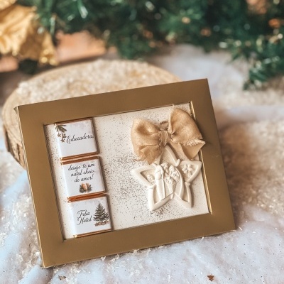 Caixa dourada com chocolates e decoração de estrela natalícia