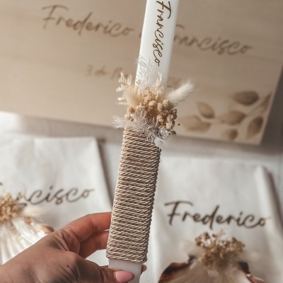 Vela branca decorada com flores secas e corda dourada com nome Frederico
