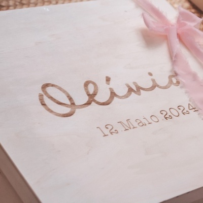 Caixa de madeira branca gravada com nome e data, decorada com laço cor-de-rosa