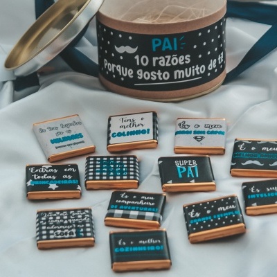 Bolachas decoradas com mensagens para pai em caixa redonda sobre tecido