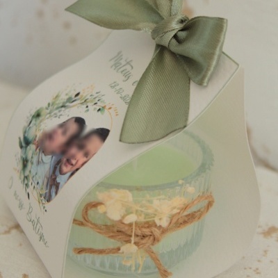 Embalagem branca com laço verde contendo vela em vidro com laço de corda