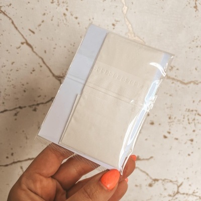 Mão a segurar lenços de papel embalatados em plástico