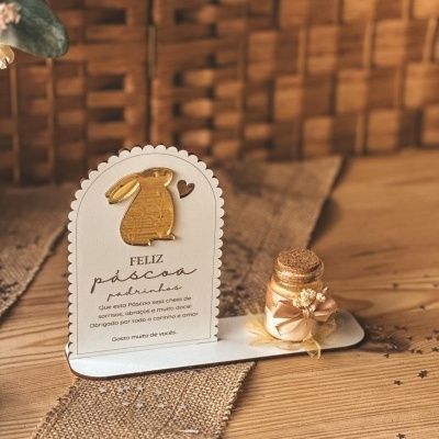 Cartão decorativo com coelho dourado e garrafa de vidro com laço dourado para decoração de Páscoa