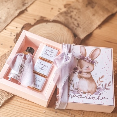 Caixa de oferta rosa com coelho ilustrado e chocolates e mini garrafa