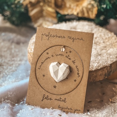 Cartão de Natal com pendente de coração branco em cartão castanho com texto manuscrito