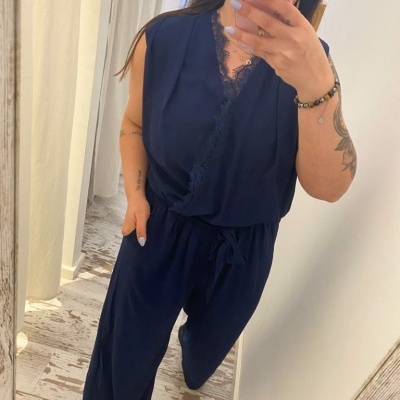 mulher vestindo macacão azul com renda em frente a espelho