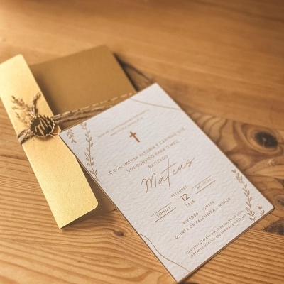Convite de batizado com envelope dourado e cartão branco texturizado com texto