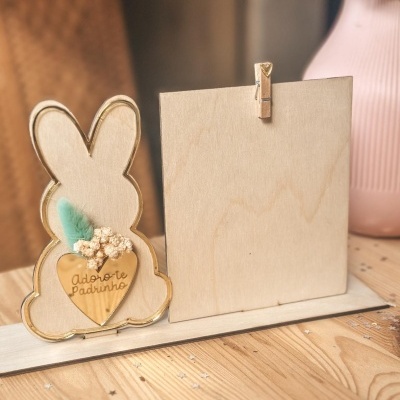 Peça decorativa em madeira em forma de coelho com coração dourado e suporte para fotografia