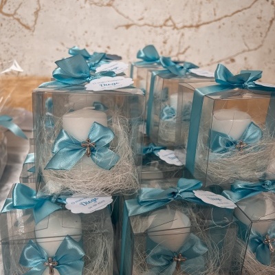 Conjunto de velas decoradas com laços azuis em caixas transparentes