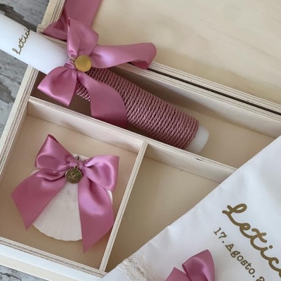 Conjunto de batismo com vela decorada, concha e toalha numa caixa de madeira