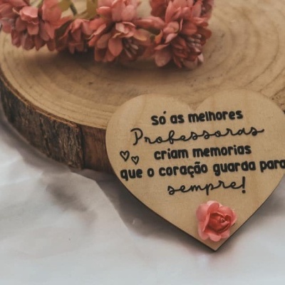 Objeto decorativo coração com texto em português sobre base de madeira