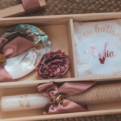 Conjunto de batismo com vela, concha, flor decorativa e toalha com texto dentro de caixa de madeira