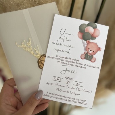 Convite de celebração especial com desenho de urso e balões, texto em português, mão segurando o convite