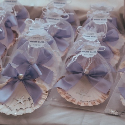 Conchas decorativas embrulhadas com laço lilás e etiqueta branca