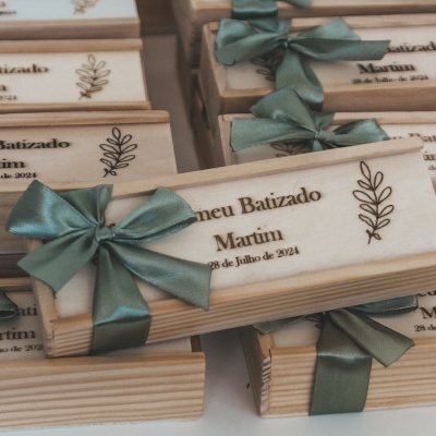 Caixas de madeira personalizadas com laços verdes e gravação para batizado
