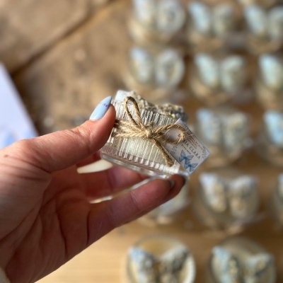 Vela pequena em vidro transparente com decoração de borboleta azul e cordão de juta