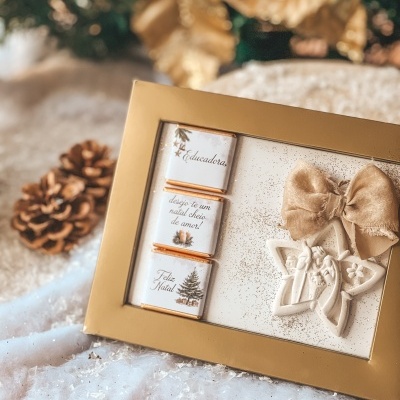 Caixa dourada com chocolates natalícios e decoração em forma de estrela com laço