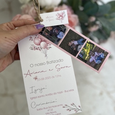 Convite de batizado decorado com balões e flores, com fotos de criança e texto em rosa e cinza.