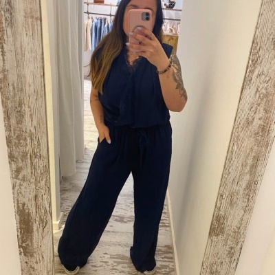 Macacão azul escuro de tecido leve com calças largas, usado por mulher em espelho