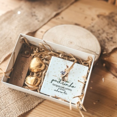 Caixa de oferta com chocolates em coração e placa decorativa para padrinho com texto em português