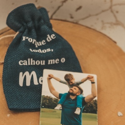 Saco azul escuro de tecido com texto em branco e fotografia de pai e filho com mensagem de feliz dia do pai