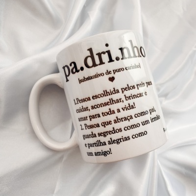 Caneca branca com texto a definir 'padrinho' em tecido branco