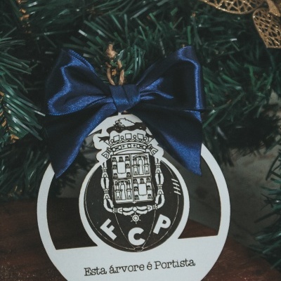 Enfeite de Natal branco com brasão FCP e laço azul numa árvore de Natal