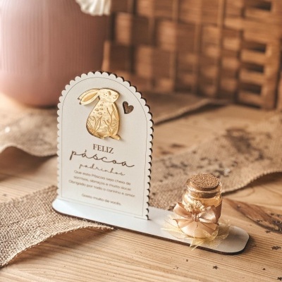 Decoração de Páscoa em madeira com coelho dourado e pequeno frasco de vidro com laço rosa