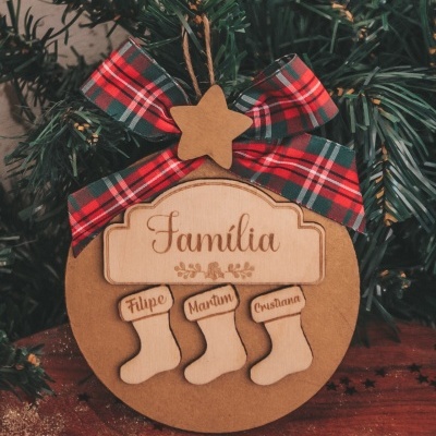 Enfeite de Natal em madeira com placa 'Familia' e meias com nomes, com laço xadrez vermelho e verde.