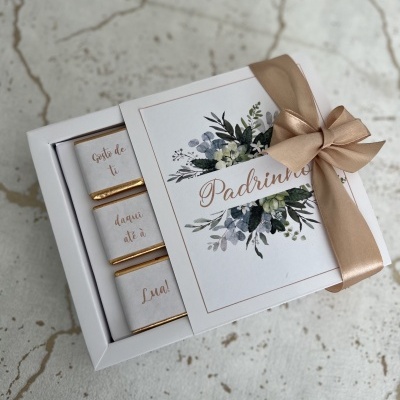 Caixa branca decorada com laço dourado e mensagem para padrinhos com chocolates