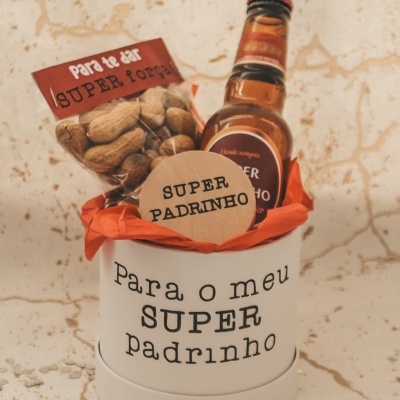 Presente para padrinho com amendoins e cerveja em recipiente branco com texto.