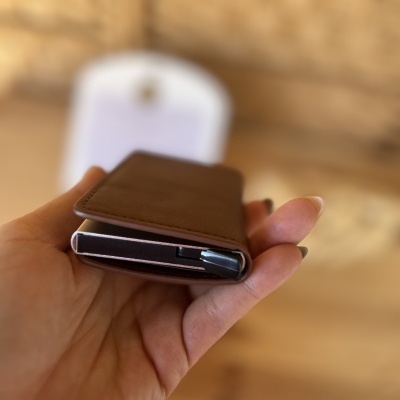 Carteira compacta em pele castanha com elementos metálicos