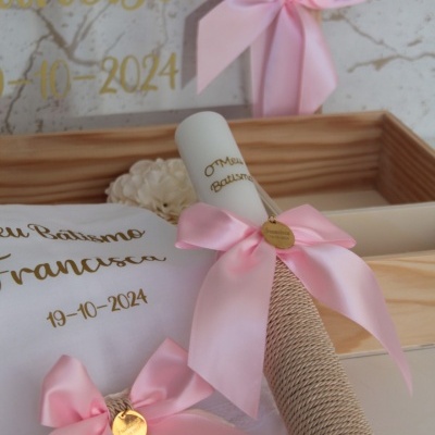 Conjunto de batismo com vela enrolada, laços rosa e cartão branco com texto dourado