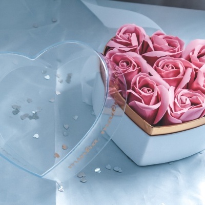 Caixa de coração branca com rosas de tecido cor-de-rosa e tampa transparente.