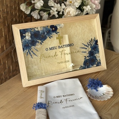 Conjunto de batismo com moldura decorativa, vela e toalha brancas com texto personalizado e flores azuis